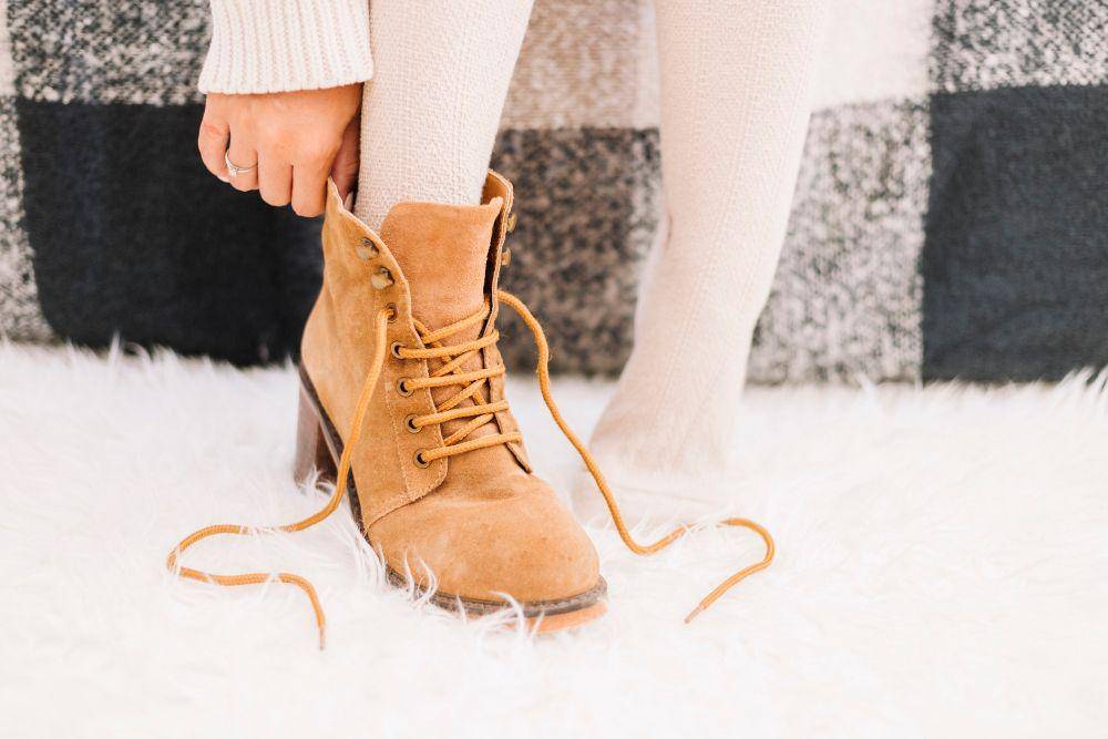 ilustrasi seorang wanita memakai sepatu boots saat musim dingin (freepik.com/freepik)