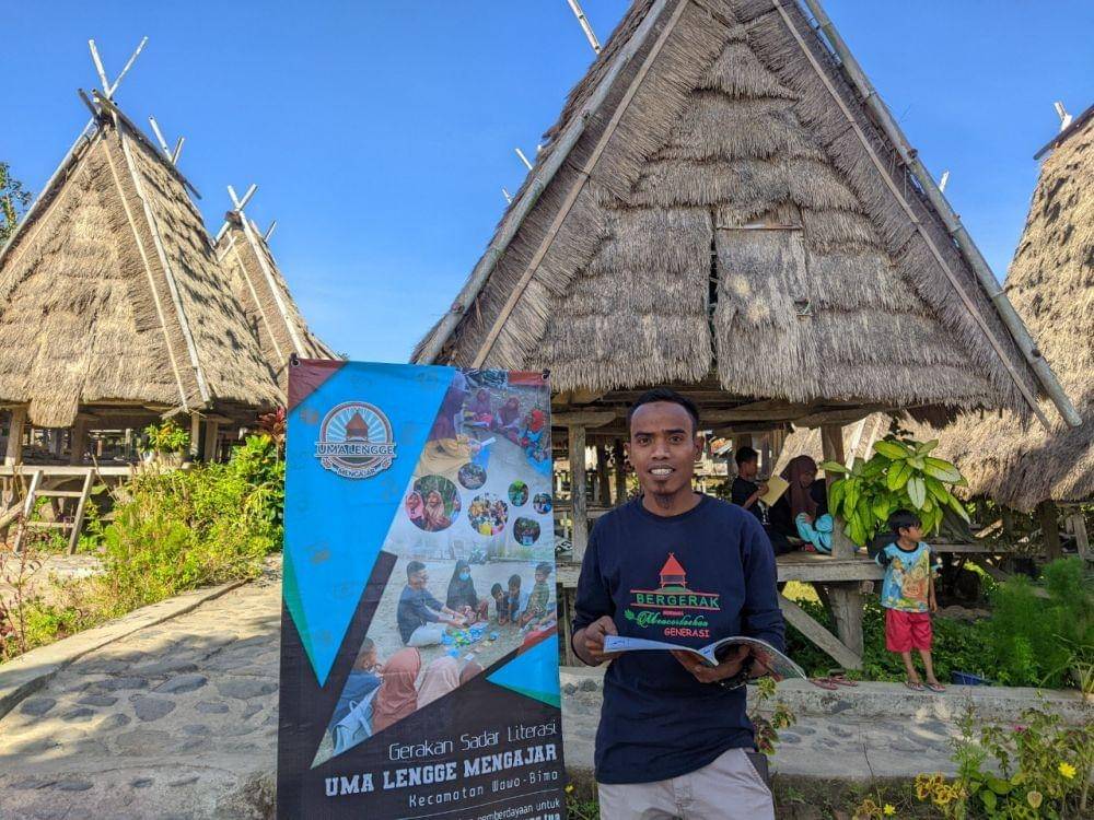Ahmad, pegiat pendidikan di Kecamatan Wawo, Kab. Bima, Nusa Tenggara Barat, mengajak anak-anak membaca buku di Uma Lengge Mengajar. Dok. Kemendikbudristek