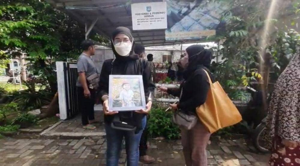 Ibu sambung korban memperlihatkan foto korban semasa hidup di rumah duka, Kelurahan Depok Jaya, Kecamatan Pancoran Mas, Kota Depok. (IDNTimes/Dicky)