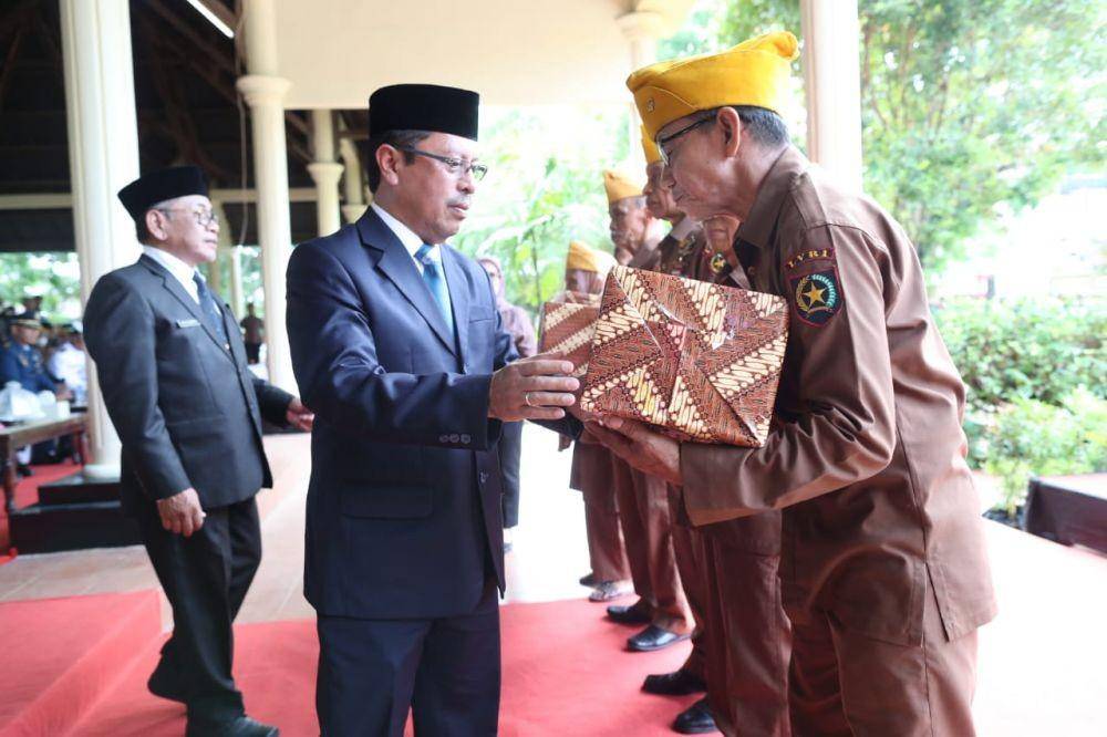Sekretaris Daerah Kota Makassar Muhammad Ansar menyerahkan bantuan pada legiun veteran saat upacara peringatan Hari Korban 40.000 Jiwa di Monumen Korban 40.000 Jiwa di Makassar, Minggu (11/12/2022). Dok. Pemkot Makassar