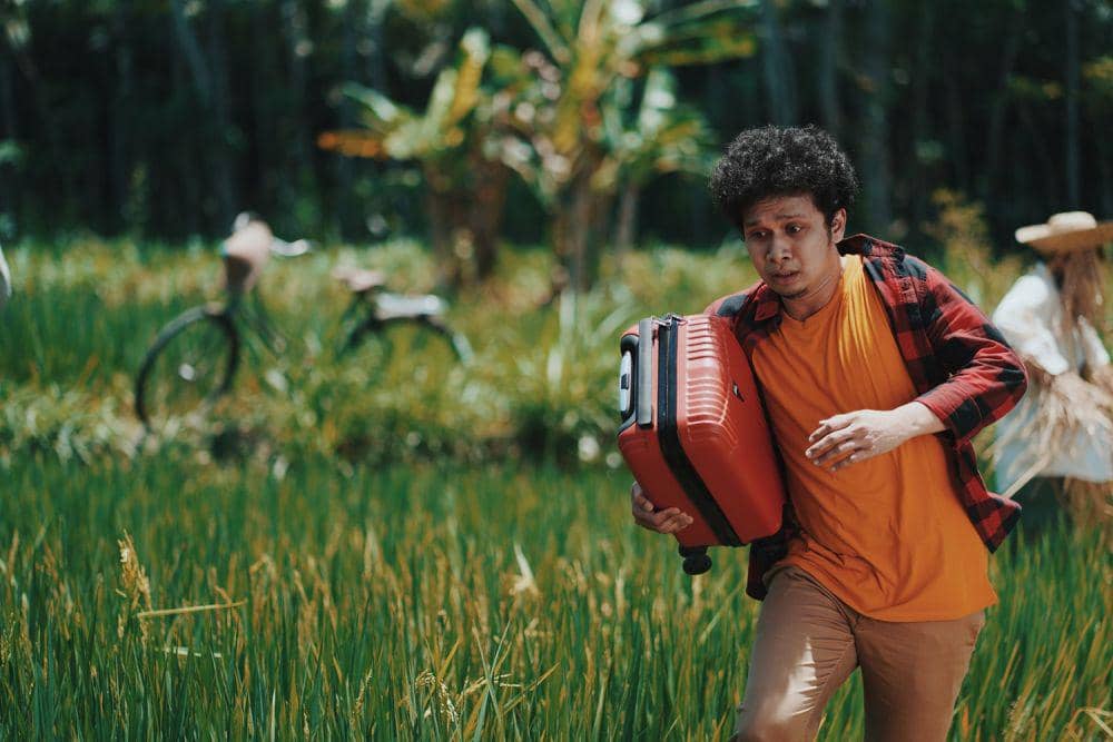 gambar pria sedang berlari dengan koper karena panik (unsplash.com/Rendy Novantino)