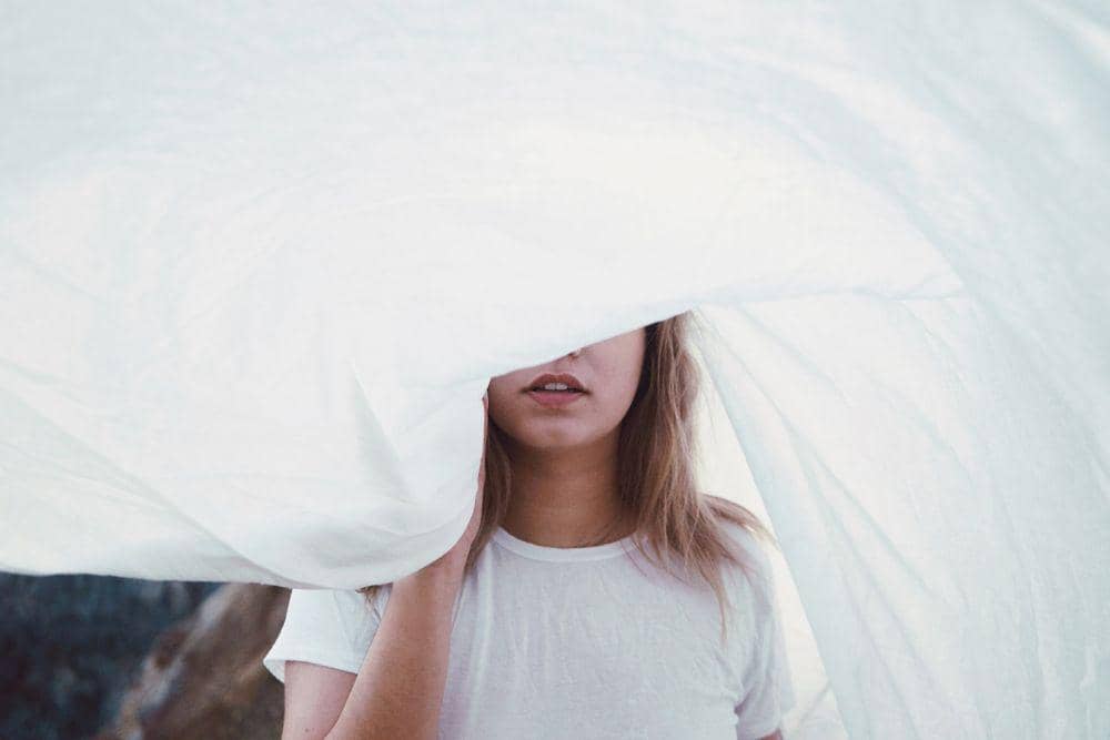 gambar orang sedang bersembunyi dibalik kain (unsplash.com/Yoann Boyer)