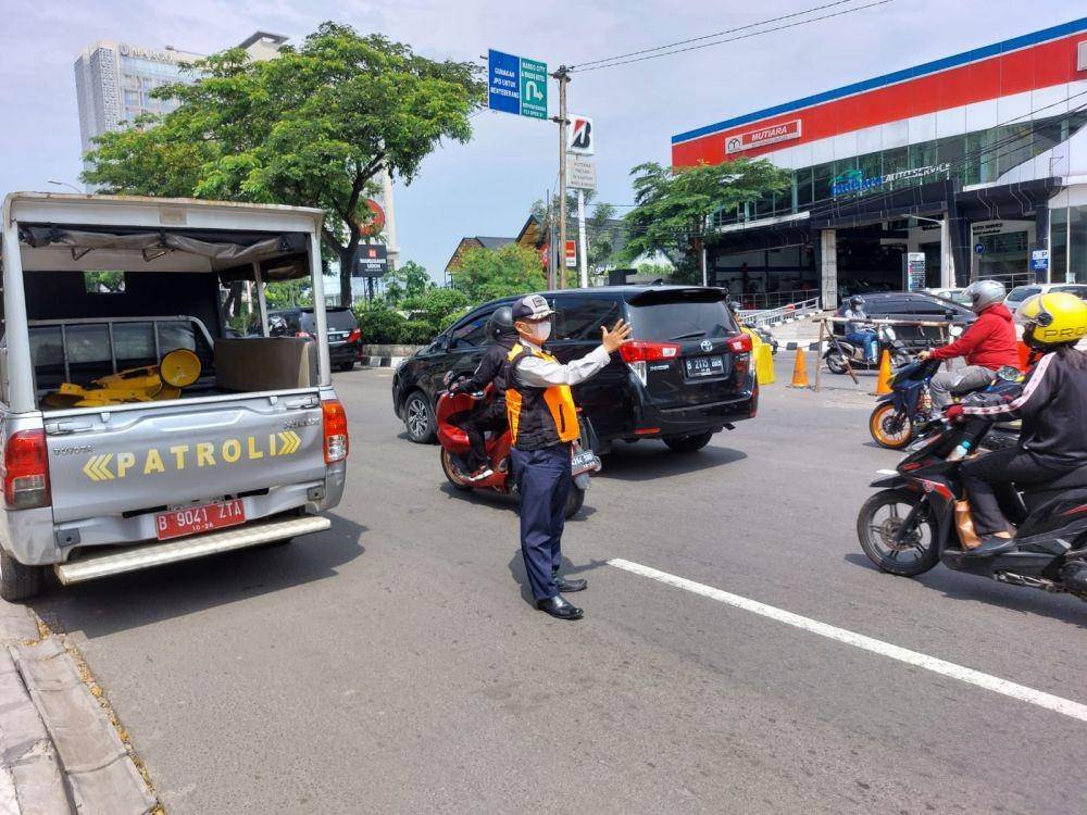 Petugas Dishub Kota Depok mengatur lalu lintas di U-Turn yang telah di tutup di Jalan Raya Margonda, Kota Depok. (IDNTimes/Dicky)