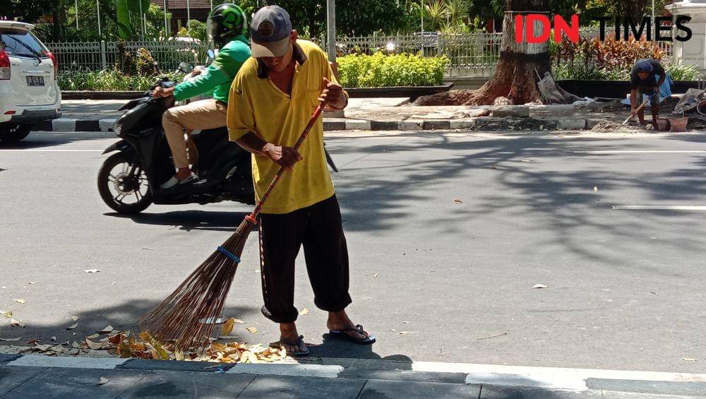 Petugas kebersihan menyapu sampah yang berada di depan kantor Gubernur NTB. (IDN Times/Muhammad Nasir)