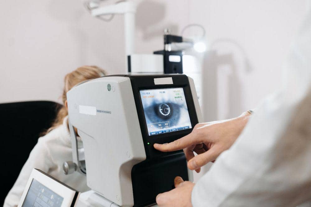 Seorang anak menjalani pemeriksaan mata bersama tenaga medis menggunakan alat optik di ruang klinik.