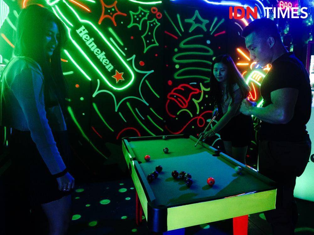 Pengunjung bermain mini billiard di event Heineken Christmas Experience yang digelar di Ashta District 8, Jakarta, Rabu (21/12). (IDN Times/Ridho Fauzan)