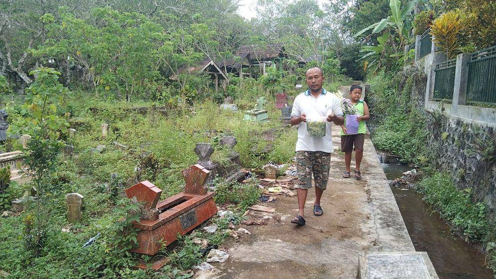 Vincensius dan adik laki-laki Revano saat mendatangi makam Revano. (IDN Times/Rizal Adhi Pratama)