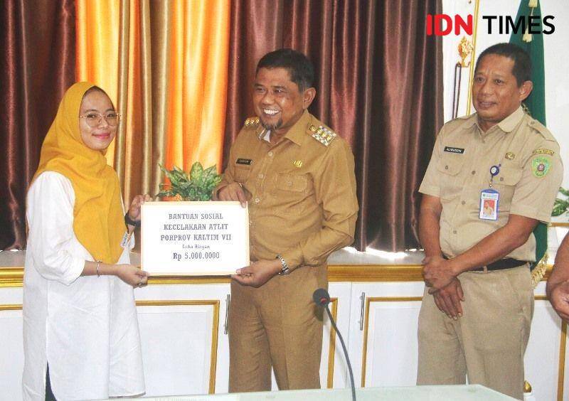 Bupati PPU Hamdam didampingin Kadispora Alimuddin menyerahkan santunan kepada perwakilan atlet yang cidera ringan (IDN Times/Ervan)
