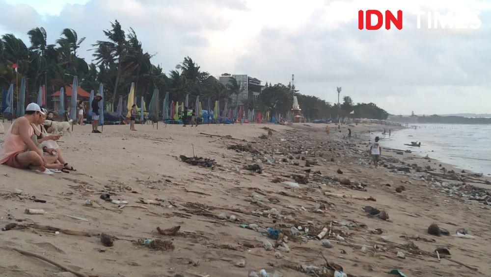 Potret Wisatawan Menikmati Pantai Legian di Tengah Kepungan Sampah