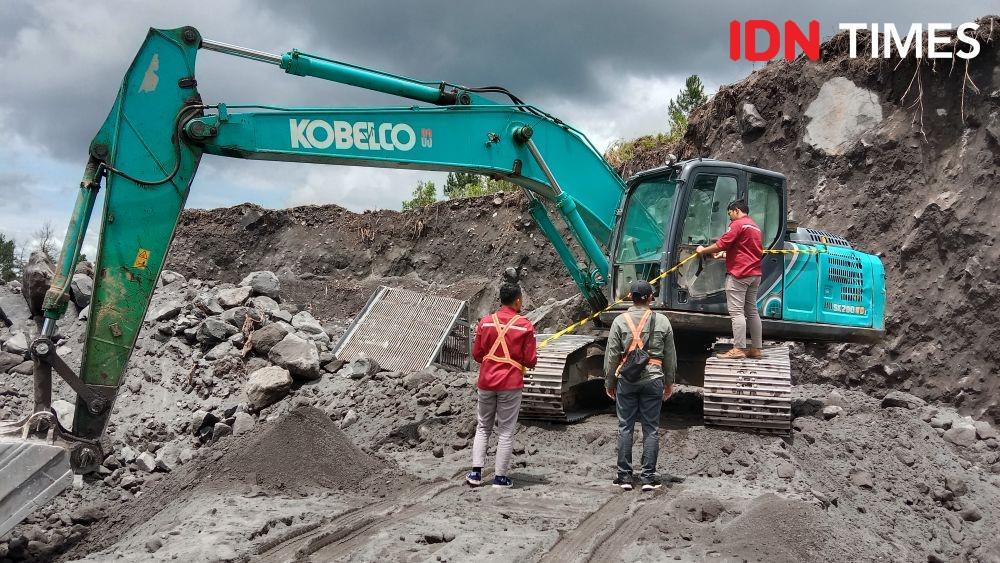 Petugas Dinas ESDM memasang garis kuning untuk tindakan preventif di lokasi tambang ilegal Desa Kemiren Srumbung. (IDN Times/Fariz Fardianto)