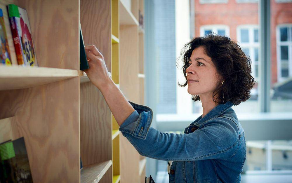 ilustrasi wanita memilih buku. (unsplash.com/Alexei Maridashvili)