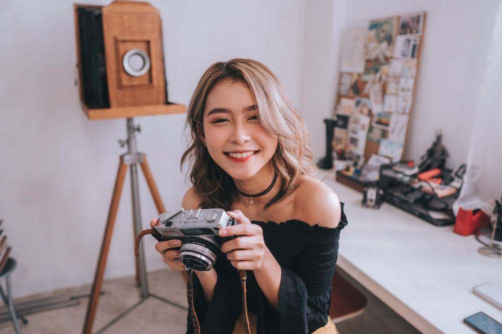 Ilustrasi perempuan memegang kamera. (pexels.com/Christian Diokno)