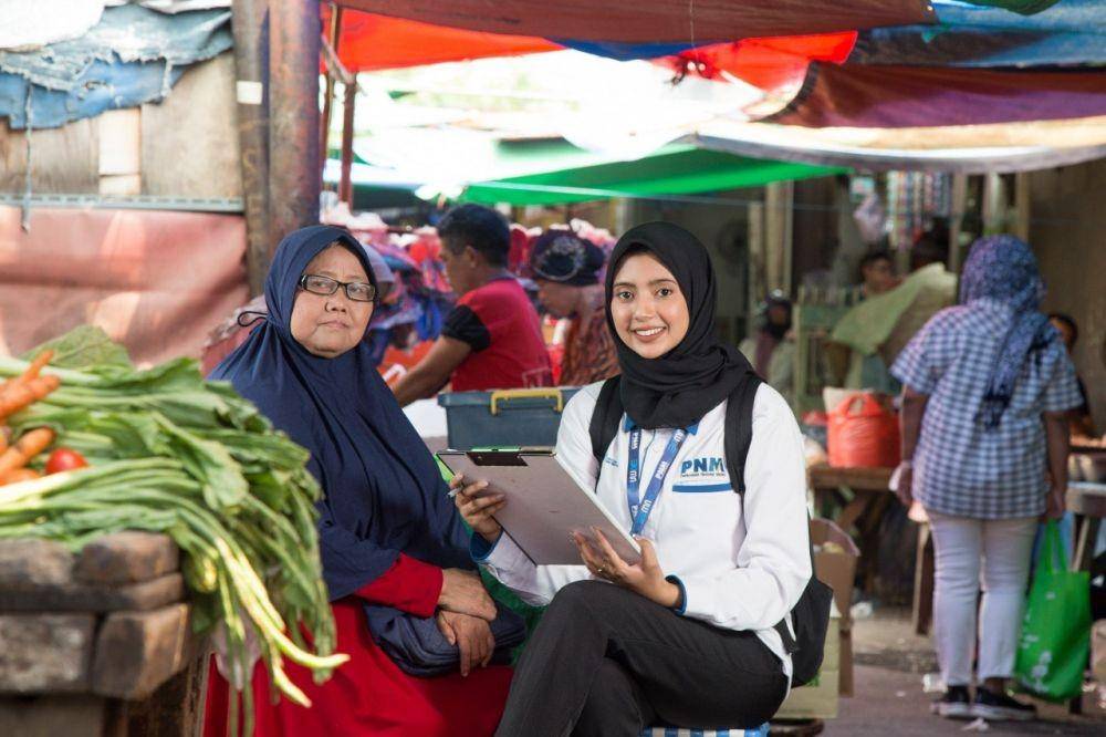 Pekerja PNM Mekaar bersama nasabah berada di pasar tradisional. (Dok. PNM)