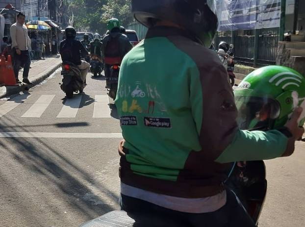 Caption foto: Mitra Driver Gojek, Sugeng, yang sedang menolong teman difabel. (https://twitter.com/@tubbirfess)