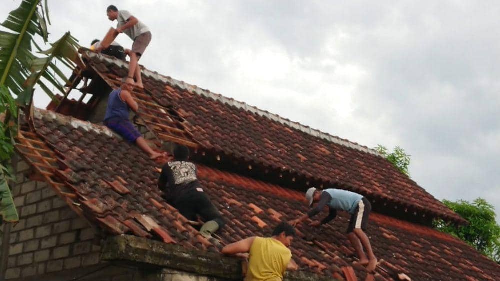 Warga memperbaiki atap rumah yang rusak terkena puting beliung. IDN Times/ istimewa