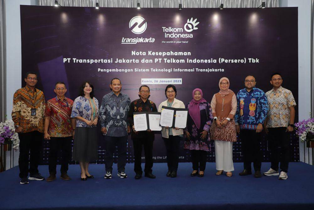 Direktur Enterprise and Business Service Telkom FM Venusiana R. (kelima dari kanan), Direktur Utama Transjakarta M. Kuncoro Wibowo (kelima dari kiri) berfoto bersama usai proses penandatanganan nota kesepahaman Pengembangan Sistem Teknologi Informasi Transjakarta. (Dok. Telkom)