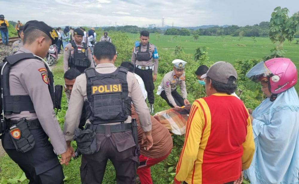 Polisi dan warga saat mengevakuasi korban kecelakaan kereta api. (Istimewa)