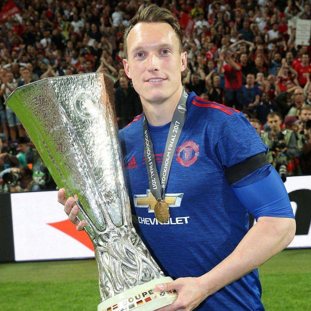 Phil Jones mengangkat trofi Europa League 2016/2017. (twitter.com/ManUtd)