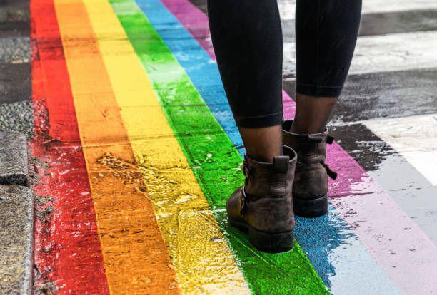 ilustrasi seseorang berjalan di penyeberangan pelangi gay (istockphoto.com/