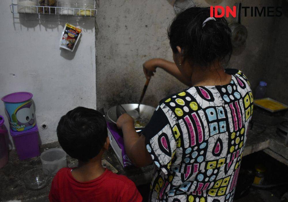 Analdi (kiri) sedang melihat ibunya, Vera (kanan) memasak pempek untuk sarapan. Debbie Sutrisno/IDN Times