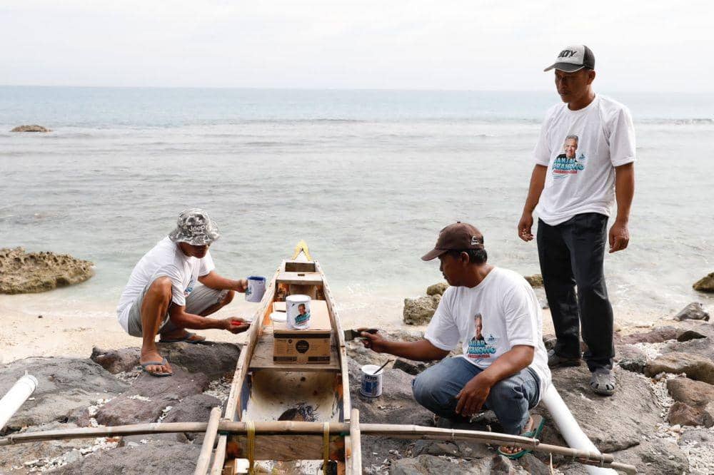 Relawan Komunitas Nelayan Pesisir memberikan bantuan berupa renovasi perahu dengan seperangkat kaleng cat dan kuas, Selasa (7/2/2023). (Dok. Komunitas Nelayan Pesisir)