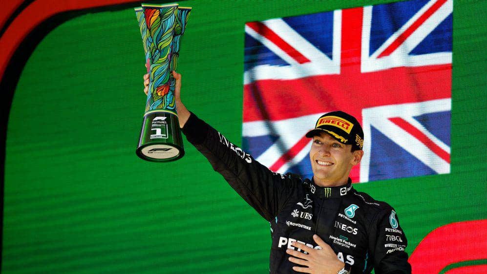 George Russell mengangkat trofi usai menang di GP Brasil 2022. (formula1.com)