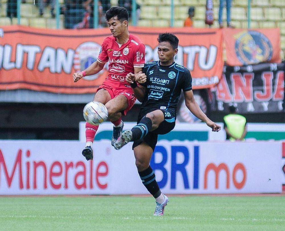 Bagas Adi Nugroho saat berduel dengan pemain Persija Jakarta. (Instagram/aremafcofficial)