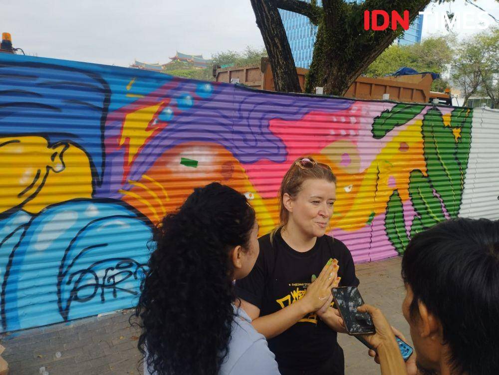 Katie Mary, muralis asal Inggris ikut mewarnai art di kawasan revitalisasi Lapangan Merdeka Medan (IDN Times/Doni Hermawan)