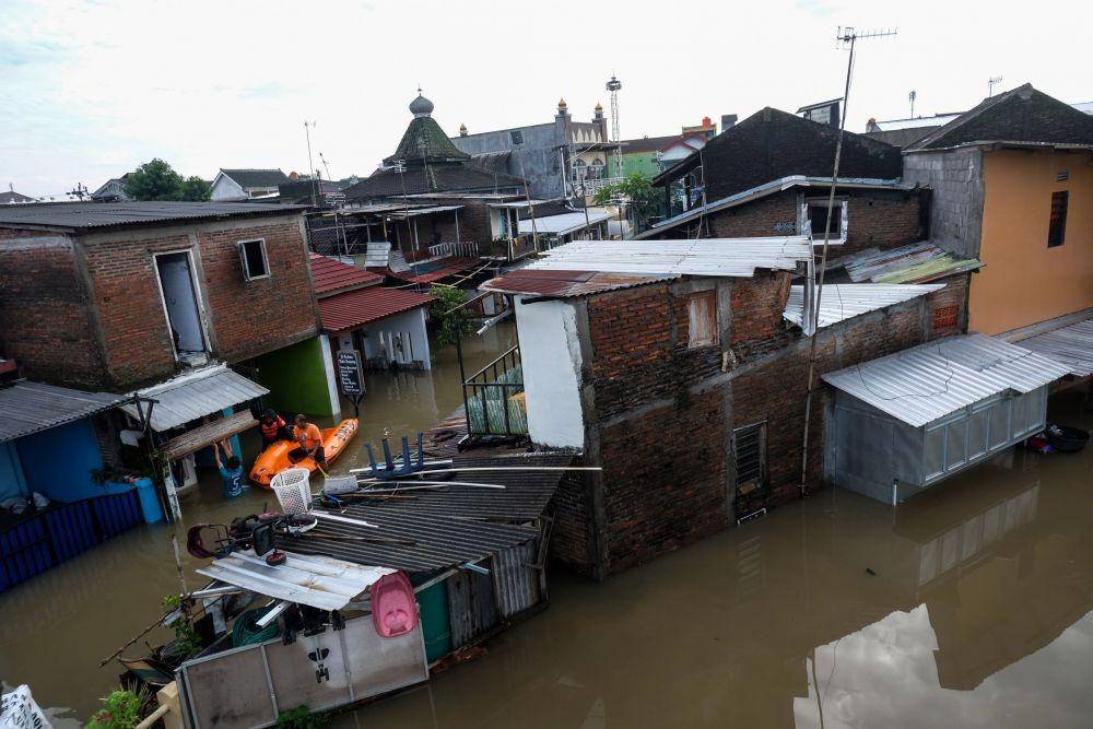 Petugas dan relawan menyisir perkampungan yang terendam banjir di Pucang Sawit, Solo, Jawa Tengah, Jumat (17/2/2023). (ANTARAFOTO/Maulana Surya)