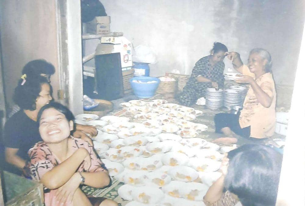 Mbah Darso menata makanan saat hajatan di kampung. (Dok/Istimewa)