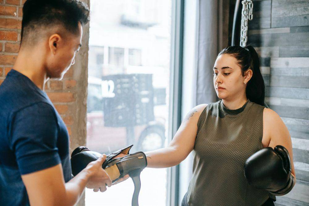 gambar seorang wanita sedang memakai sarung tinju (pexels.com/Andres Ayrton)