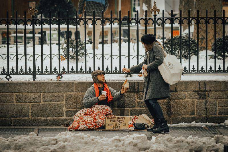 gambar perempuan berbagi makanan kepada orang yang membutuhkan (unsplash.com/Jon Tyson)