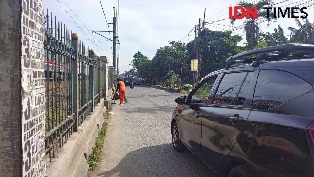 Pesapon DLHK Kota Depok saat menyapu jalan Raya Citayam, Kecamatan Cipayung, Kota Depok, tanpa menggunakan tripcone sebagai penanda keselamatan saat bekerja. (IDNTimes/Dicky)