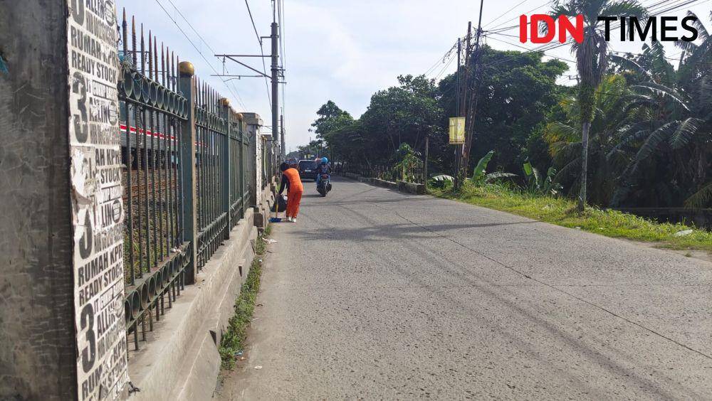 Petugas penyapu jalan DLHK Kota Depok saat menyapu di Jalan Raya Citayam, Kecamatan Cipayung, Kota Depok. (IDNTimes/Dicky)