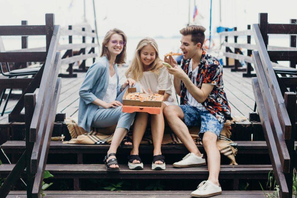lustrasi makan pizza bersama teman (pexels.com/maksim gocharenok)