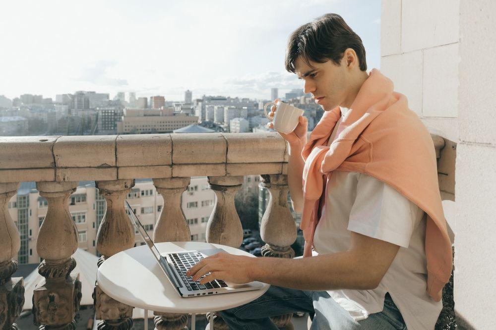 Mengetik laptop di balkon (Pexels.com/SHVETS production)