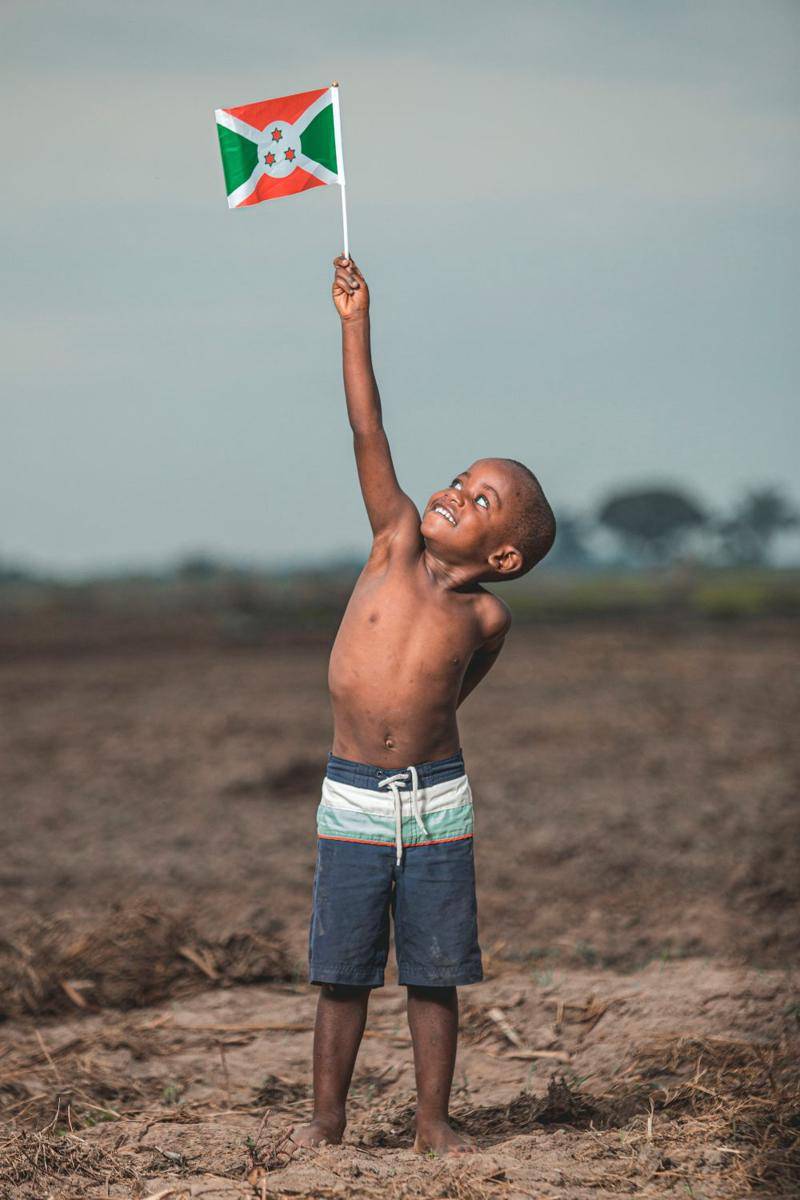 potret anak kecil mengangkat bendera Burundi (pexels.com/@safari-consoler-3290243)