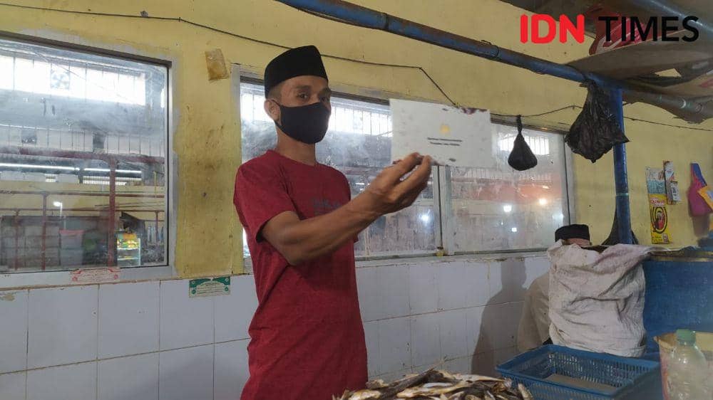 Seorang pedagang di Pasar Tradisional Modern Kabupaten Maros menerima BLT dari Presiden Jokowi. (IDN Times/Ashrawi Muin)