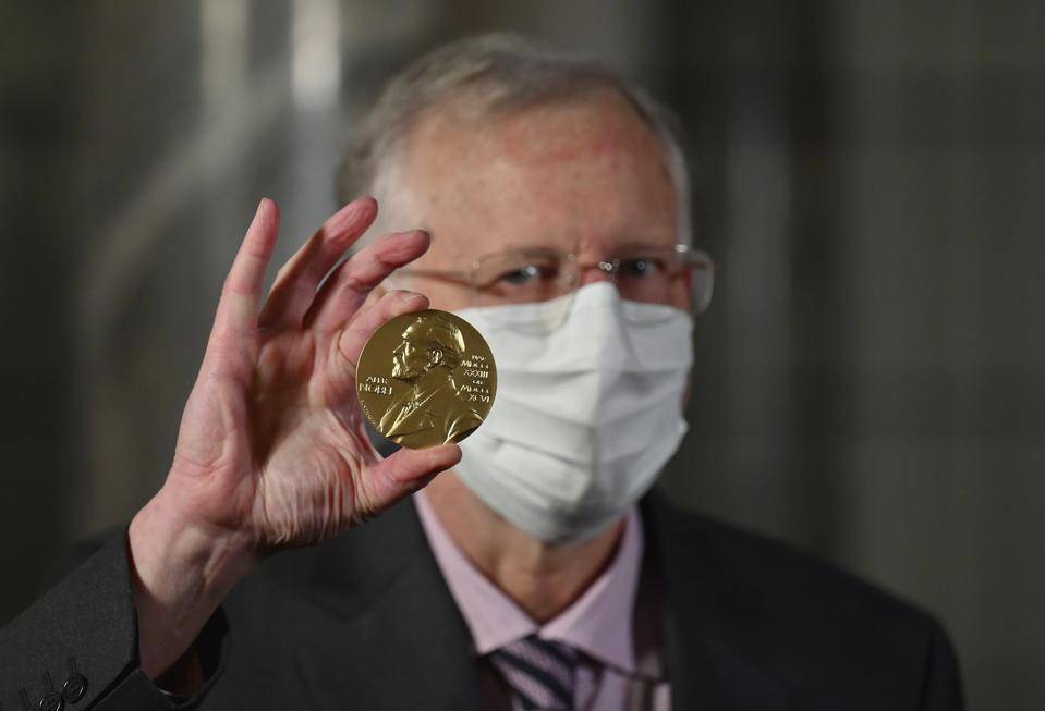 Ahli virologi Amerika Charles M. Rice berpose dengan medali hadiah Nobelnya. (ASSOCIATED PRESS via forbes.com))