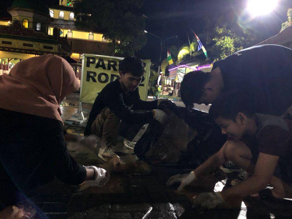 Sejumlah relawan dari Mapala Uniska berjibaku membersihkan sampah di arean haul Guru Zuhdi.