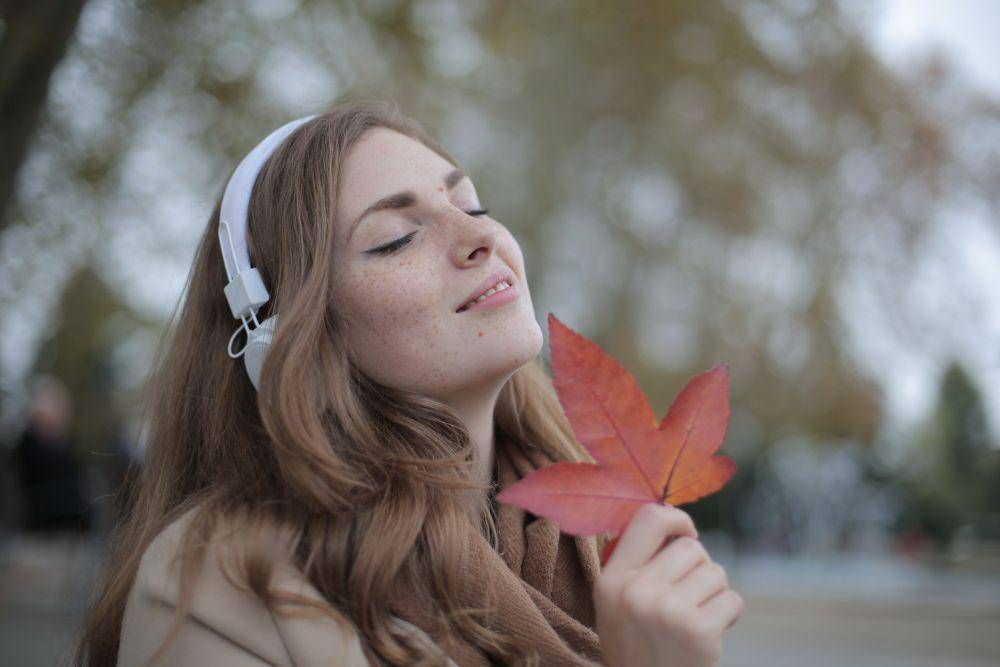 wanita muda dan daun merah (pexels.com/Andrea Piacquadio)