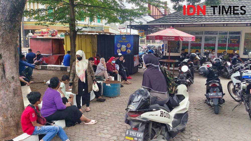 Sejumlah warga yang datang tampak duduk usai mengetahui pengobatan Ida Dayak dibatalkan di Markas Kostrad, Kecamatan Cilodong, Kota Depok. (IDNTimes/Dicky)