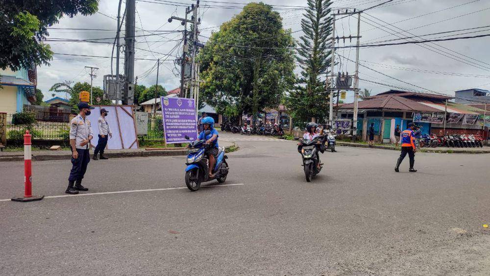 Pegawai Dinas Perhubungan mengatur lalu lintas sekaligus menyosialisasi pelaksanaan uji publik rekayasa lalu lintas baru di Jalan Budi Utomo. (IDN Times/Endy Langobelen)