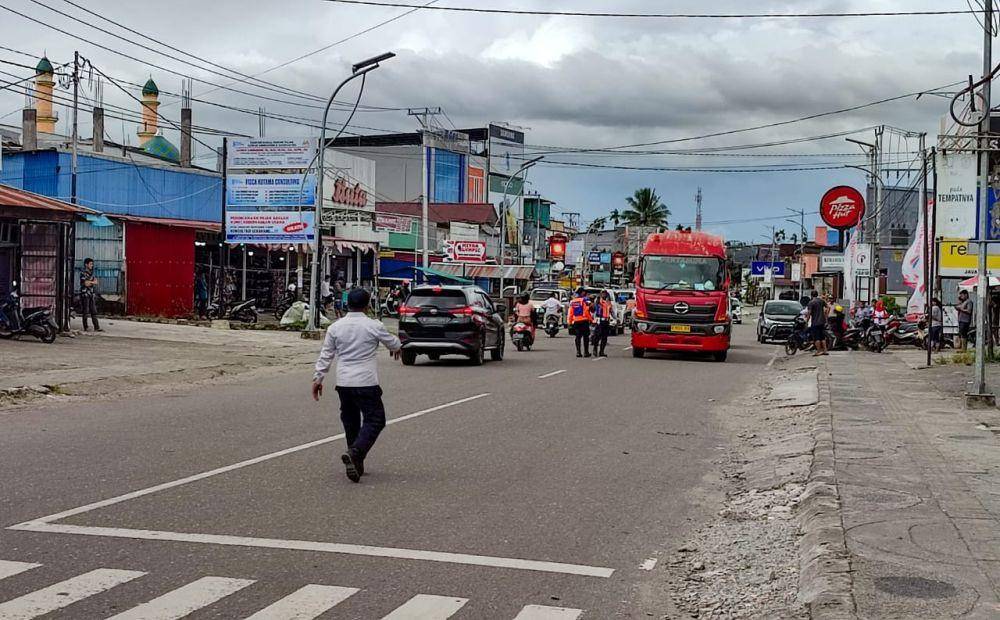Pegawai Dinas Perhubungan Kabupaten Mimika mengarahkan para pengendara untuk putar balik sesuai penerapan satu arah di Jalan Budi Utomo, Rabu (5/4/2023). (IDN Times/Endy Langobelen)