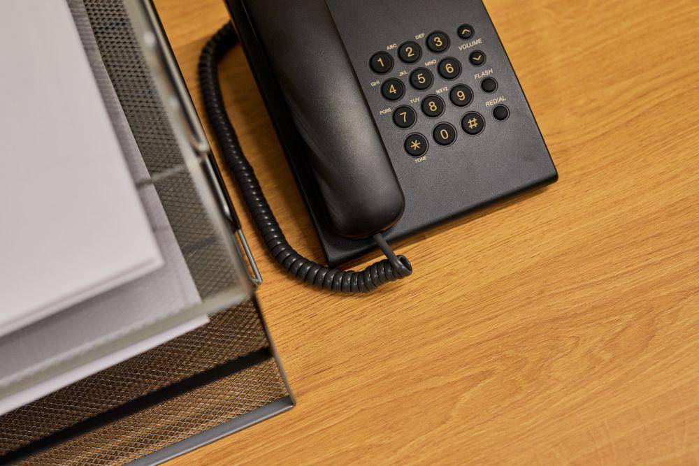 ilustrasi telepon dan buku di atas meja (pexels.com/Ron Lach)