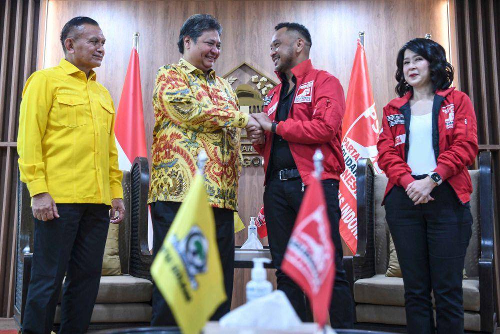Ketua Umum Partai Golkar Airlangga Hartarto (kedua kiri) berjabat tangan dengan Ketua Umum Partai Solidaritas Indonesia (PSI) Giring Ganesha (kedua kanan) disaksikan Sekretaris Jenderal Partai Golkar Lodewijk Freidrich Paulus (kiri) dan Wakil Ketua Dewan Pembina PSI Grace Natalie (kanan) saat melakukan pertemuan di Kantor DPP Partai Golkar, Slipi, Jakarta, Rabu (12/4/2023). (ANTARA FOTO/M Risyal Hidayat)