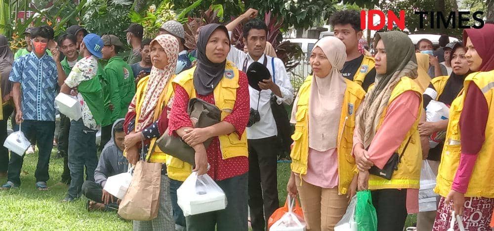 Pasukan kuning atau petugas kebersihan di Kota Mataram saat antre menerima bantuan beras di Pendopo Gubernur NTB, Rabu (12/4/2023). (IDN Times/Muhammad Nasir)