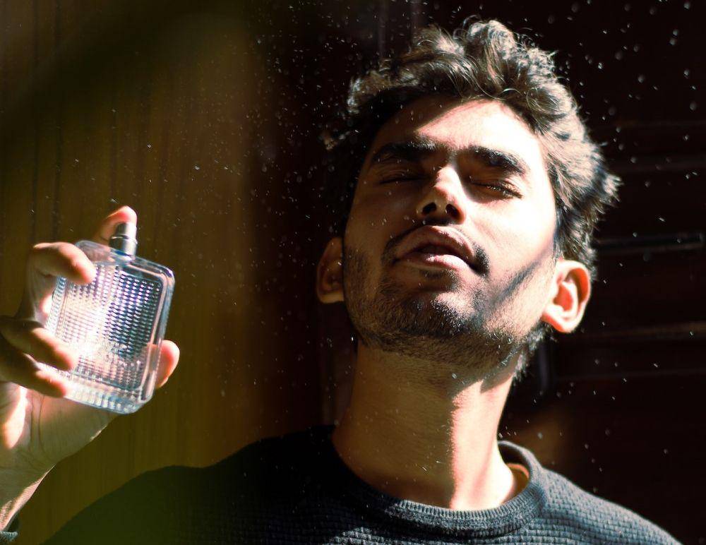 ilustrasi pria memegang parfum (pexels.com/DEBRAJ ROY)
