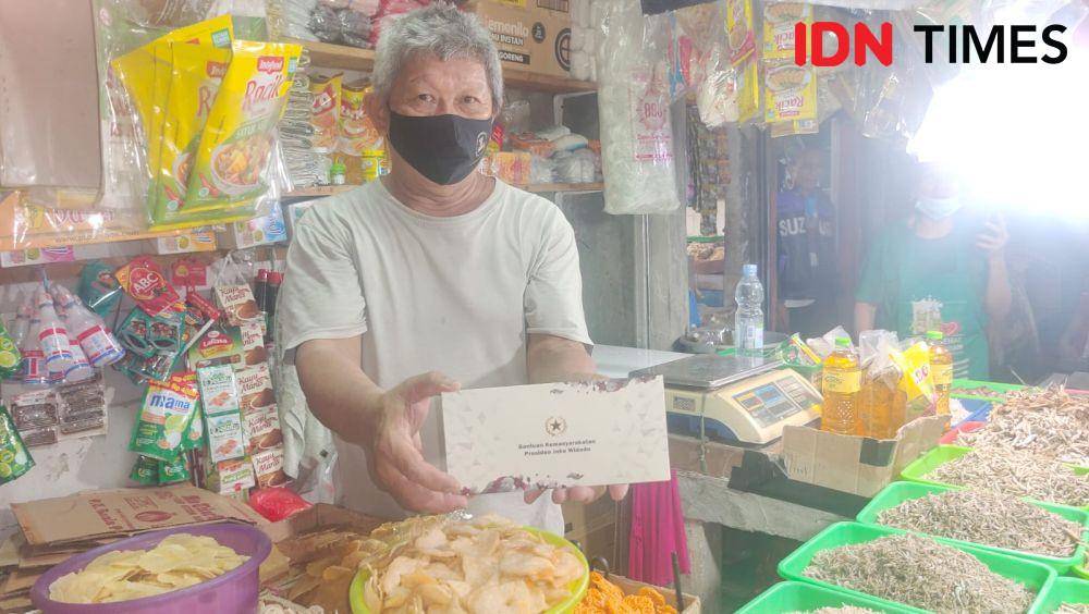 Pedagang ikan asin, Jun Fong mendapatkan amplop bantuan presiden saat Jokowi belusukan di Pasar Tugu, Kecamatan Cimanggis, Kota Depok. (IDNTimes/Dicky)