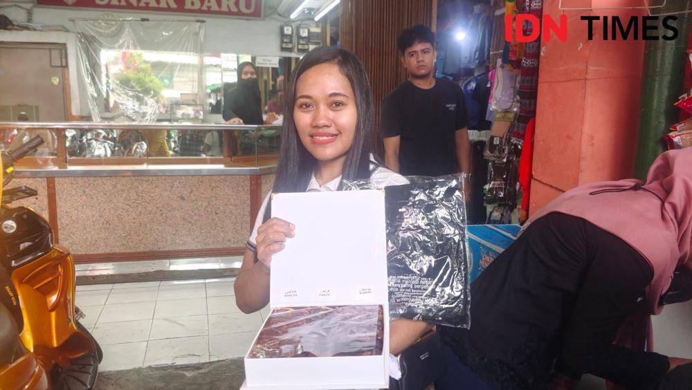 Pedagang warung kelontong, Aisyah mendapatkan kaos dan kurma saat Jokowi datang ke Pasar Tugu, Kecamatan Cimanggis, Kota Depok. (IDNTimes/Dicky)
